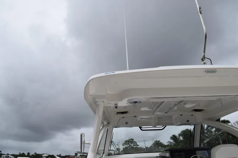  Yacht Photos Pics 2022 Pursuit OS 355 Offshore boat under cloudy sky, showcasing helm and hardtop.