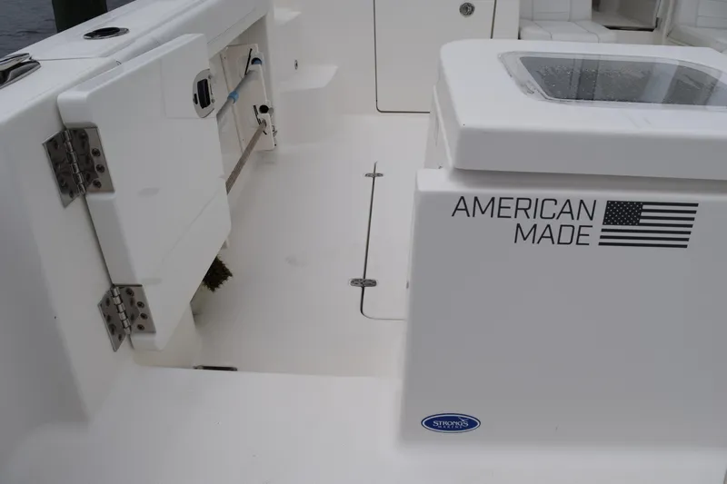  Yacht Photos Pics 2022 Pursuit OS 355 Offshore boat interior, featuring "American Made" branding and storage compartments.