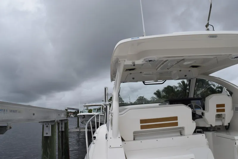  Yacht Photos Pics 2022 Pursuit OS 355 Offshore boat docked under cloudy skies.