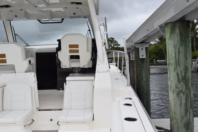  Yacht Photos Pics 2022 Pursuit OS 355 Offshore boat docked, featuring white seating and sleek design.