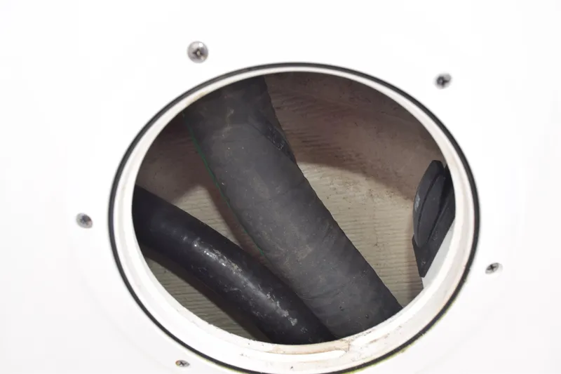  Yacht Photos Pics Close-up of 2022 Pursuit OS 355 Offshore boat's hose connections inside a circular access panel.