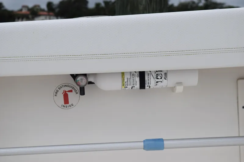  Yacht Photos Pics Fire extinguisher on 2022 Pursuit OS 355 Offshore boat, secured under a white panel.