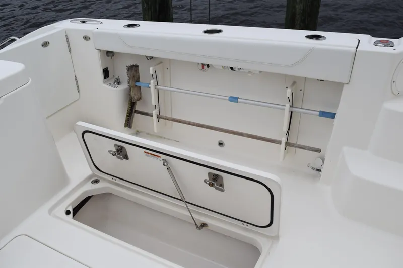  Yacht Photos Pics 2022 Pursuit OS 355 Offshore boat storage compartment with cleaning tools.