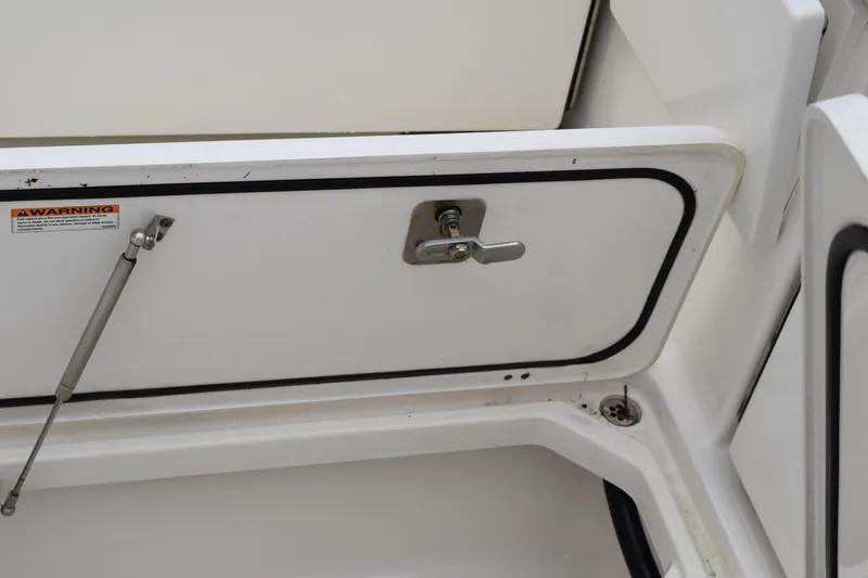  Yacht Photos Pics 2022 Pursuit OS 355 Offshore storage compartment with warning label and latch.