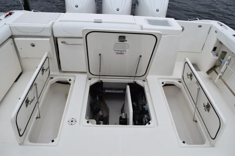  Yacht Photos Pics 2022 Pursuit OS 355 Offshore boat deck with open storage compartments and engine access.