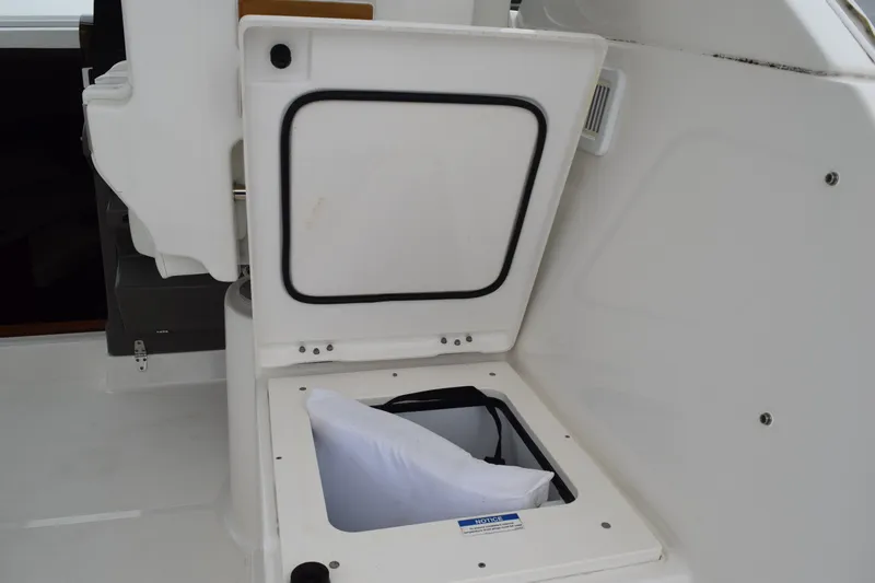  Yacht Photos Pics Storage compartment on 2022 Pursuit OS 355 Offshore boat, open with visible cushion inside.