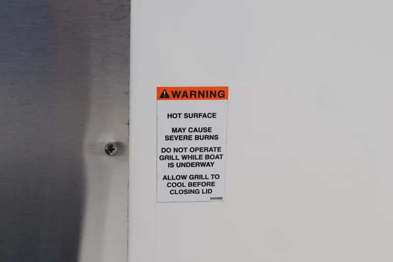  Yacht Photos Pics Warning label on 2022 Pursuit OS 355 Offshore boat grill, cautioning about hot surface burns.