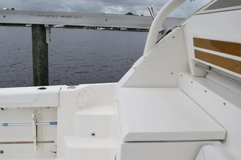  Yacht Photos Pics 2022 Pursuit OS 355 Offshore boat interior with seating and wooden accents by the water.