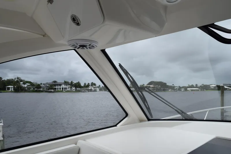  Yacht Photos Pics Interior view from 2022 Pursuit OS 355 Offshore boat, overlooking a waterfront with houses.
