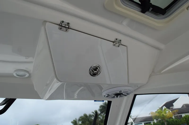  Yacht Photos Pics 2022 Pursuit OS 355 Offshore interior storage compartment with speaker and window view.