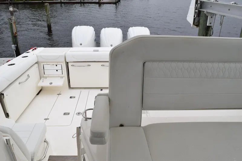  Yacht Photos Pics 2022 Pursuit OS 355 Offshore boat interior with seating and storage, docked by the water.