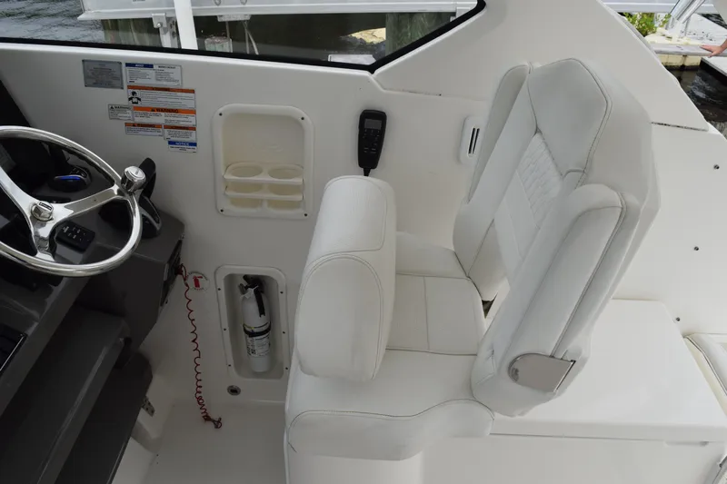  Yacht Photos Pics 2022 Pursuit OS 355 Offshore helm with white captain's seat and steering wheel.