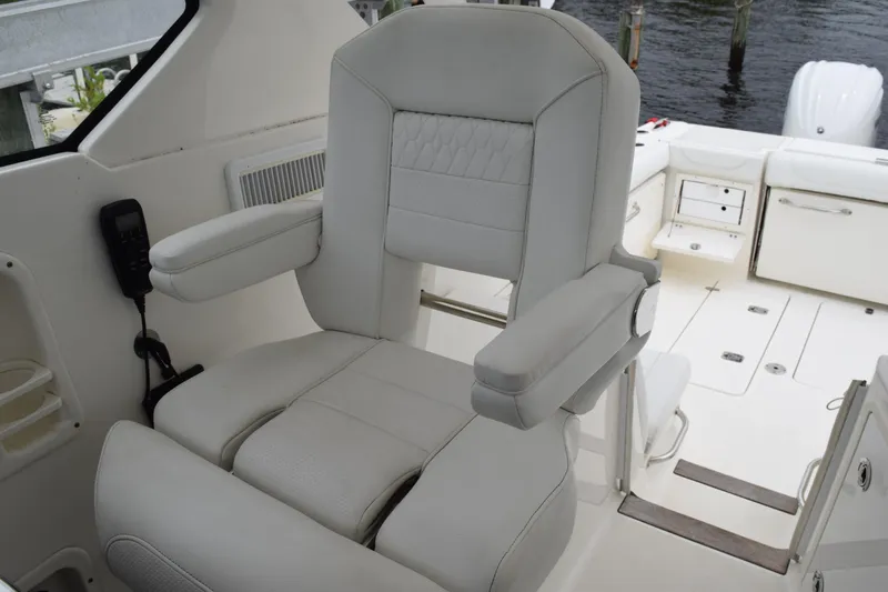  Yacht Photos Pics Captain's chair on 2022 Pursuit OS 355 Offshore boat, featuring luxurious white upholstery.