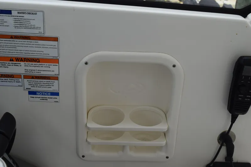  Yacht Photos Pics Control panel of 2022 Pursuit OS 355 Offshore boat with warning labels and cup holders.