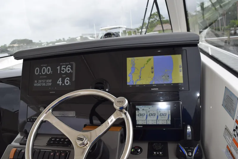  Yacht Photos Pics 2022 Pursuit OS 355 Offshore boat dashboard with navigation screens and steering wheel.