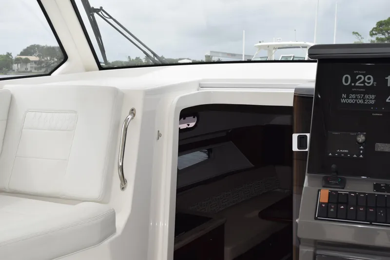  Yacht Photos Pics 2022 Pursuit OS 355 Offshore boat interior with GPS display and seating area.