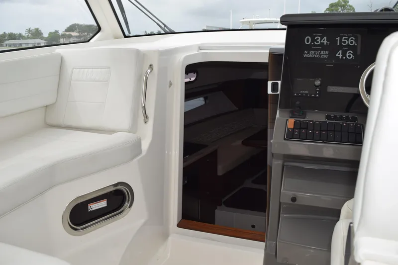  Yacht Photos Pics 2022 Pursuit OS 355 Offshore boat interior with navigation console and seating area.