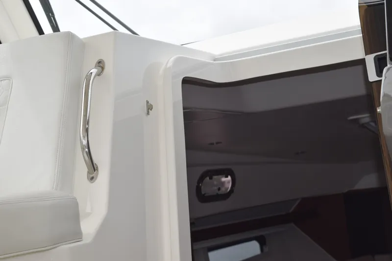  Yacht Photos Pics 2022 Pursuit OS 355 Offshore cabin entrance with sleek interior and stainless steel handle.