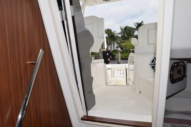  Yacht Photos Pics 2022 Pursuit OS 355 Offshore boat interior with open door, dockside view.