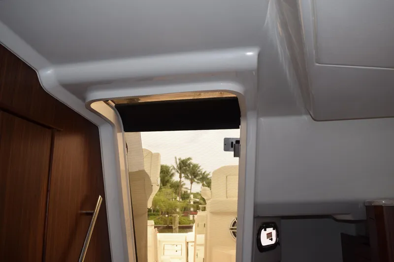  Yacht Photos Pics Interior view of 2022 Pursuit OS 355 Offshore boat, showcasing cabin entrance and wood paneling.