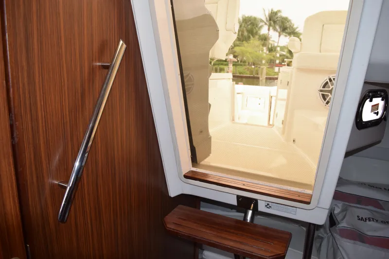  Yacht Photos Pics Interior view of 2022 Pursuit OS 355 Offshore boat, featuring wooden paneling and outdoor access.