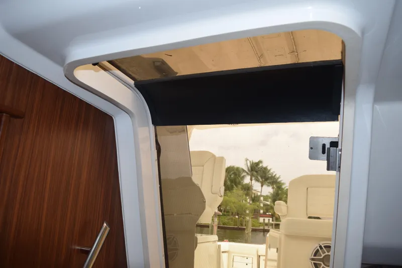  Yacht Photos Pics 2022 Pursuit OS 355 Offshore cabin entrance with wooden door and outdoor seating view.