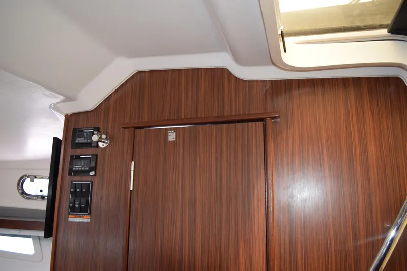  Yacht Photos Pics Interior of 2022 Pursuit OS 355 Offshore boat with wood paneling and control switches.
