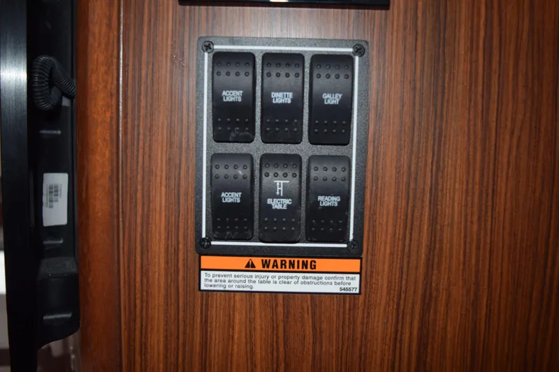  Yacht Photos Pics Control panel on 2022 Pursuit OS 355 Offshore boat with labeled switches and warning sign.