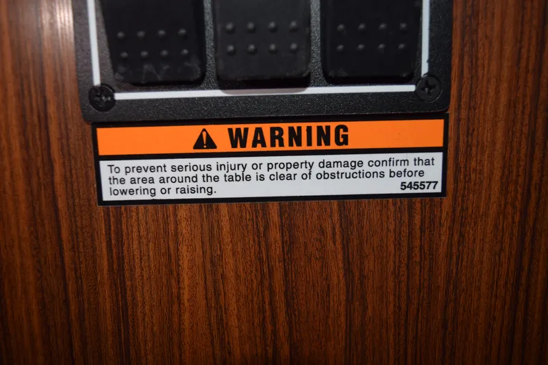  Yacht Photos Pics Warning label on 2022 Pursuit OS 355 Offshore, cautioning against obstructions near table.
