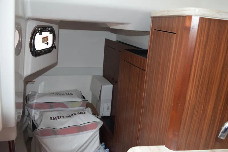  Yacht Photos Pics Interior cabin of 2022 Pursuit OS 355 Offshore with safety gear bags and wooden cabinetry.