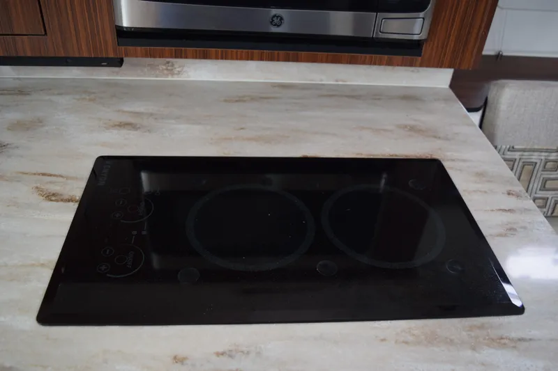  Yacht Photos Pics Modern induction cooktop on marble countertop in 2022 Pursuit OS 355 Offshore boat kitchen.