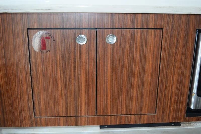  Yacht Photos Pics Wooden cabinet with fire extinguisher sign on 2022 Pursuit OS 355 Offshore boat.