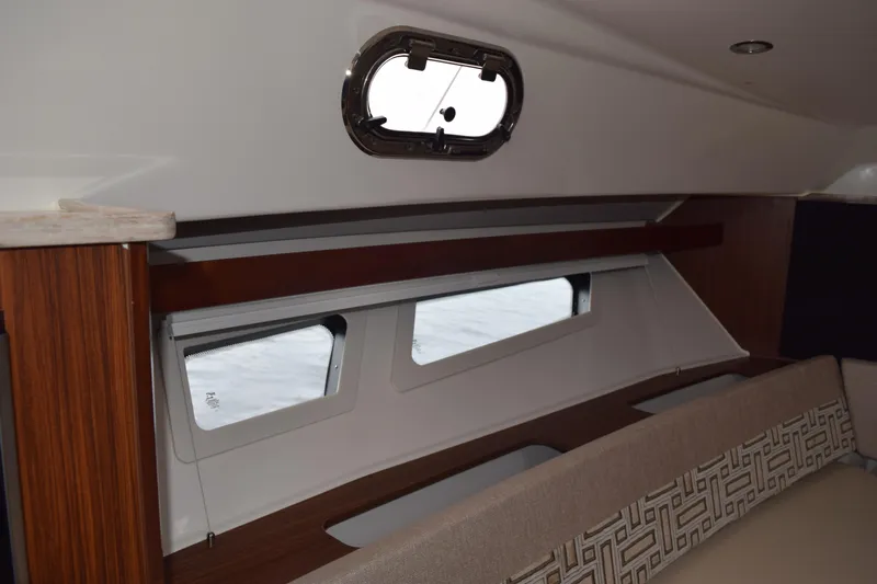  Yacht Photos Pics Interior view of 2022 Pursuit OS 355 Offshore boat cabin with windows and seating.
