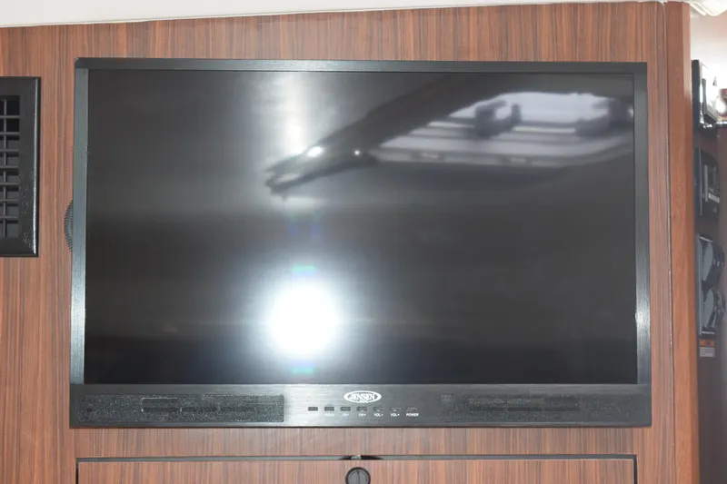  Yacht Photos Pics Flat-screen TV mounted on wood panel inside 2022 Pursuit OS 355 Offshore boat.