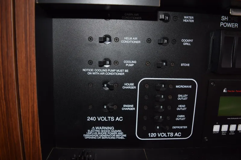  Yacht Photos Pics Control panel of a 2022 Pursuit OS 355 Offshore boat, showing electrical switches and warnings.