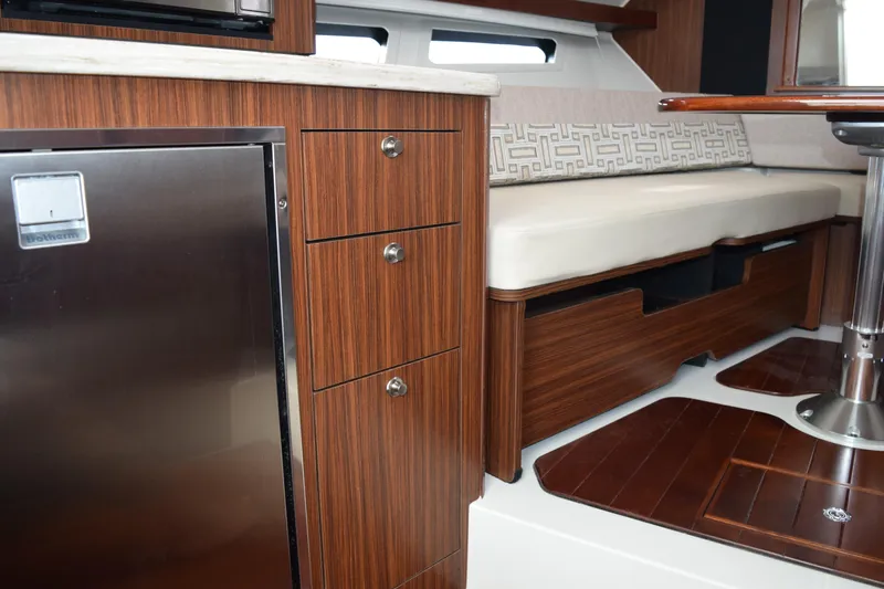  Yacht Photos Pics Luxurious interior of 2022 Pursuit OS 355 Offshore boat with wood cabinetry and seating.