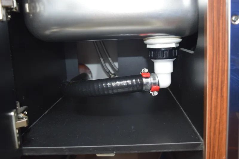  Yacht Photos Pics Under-sink plumbing in 2022 Pursuit OS 355 Offshore boat, featuring hose and fittings.