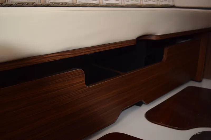  Yacht Photos Pics 2022 Pursuit OS 355 Offshore interior with wooden storage compartment and cushioned seating.