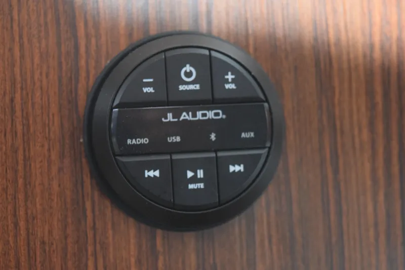  Yacht Photos Pics JL Audio control panel on 2022 Pursuit OS 355 Offshore boat, mounted on wood surface.