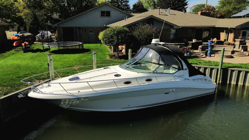  Yacht Photos Pics 2003 Sea Ray 340 Sundancer docked by a house with a lush green yard.