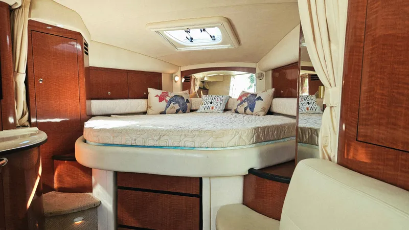  Yacht Photos Pics Luxurious interior of 2003 Sea Ray 340 Sundancer yacht with cozy bed and elegant wood finish.