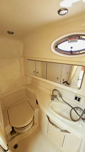  Yacht Photos Pics 2003 Sea Ray 340 Sundancer bathroom with sink, mirror, and porthole window.