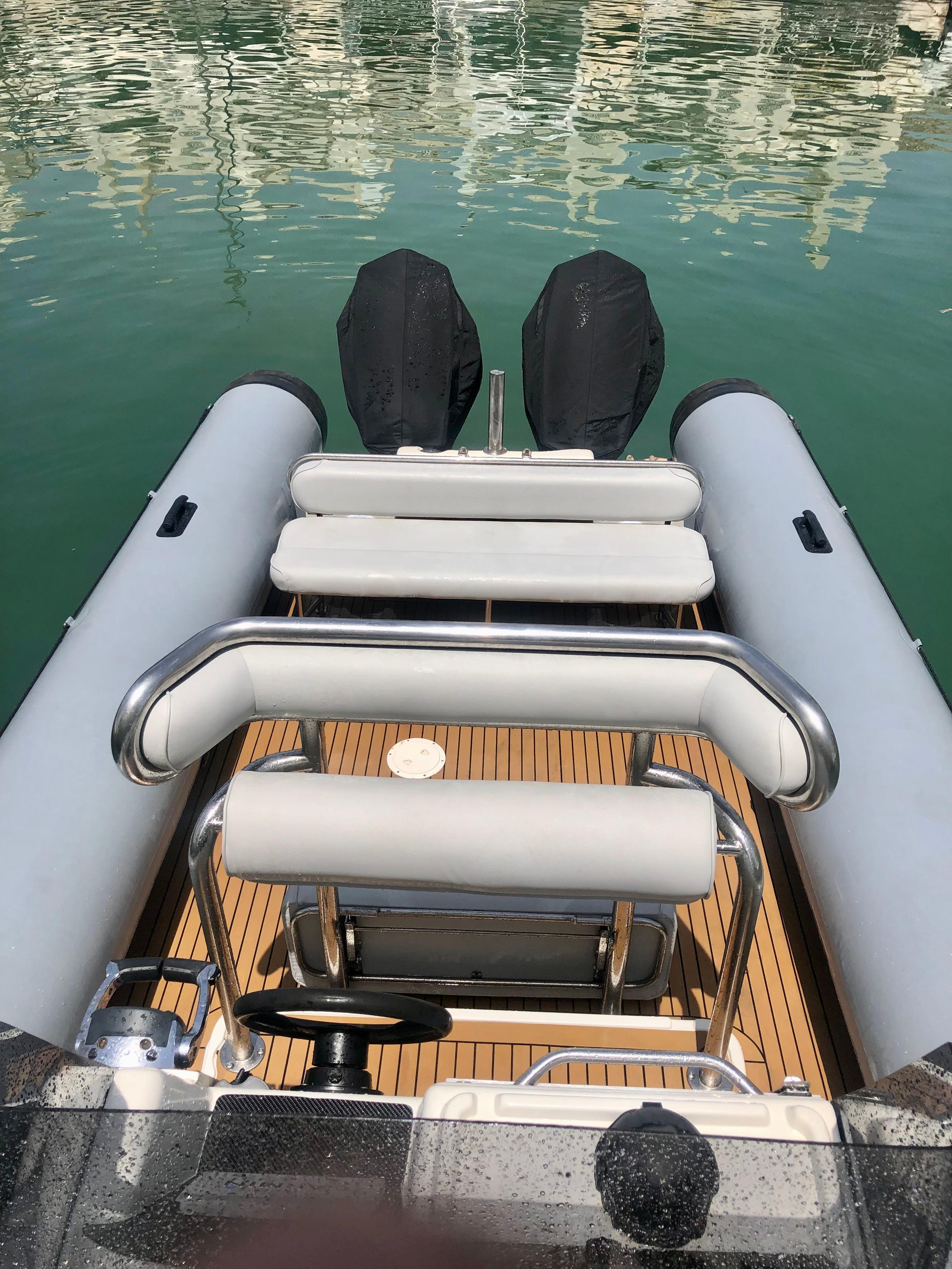 2005 Protector RIB 8.75m boat with dual engines, docked on calm water.