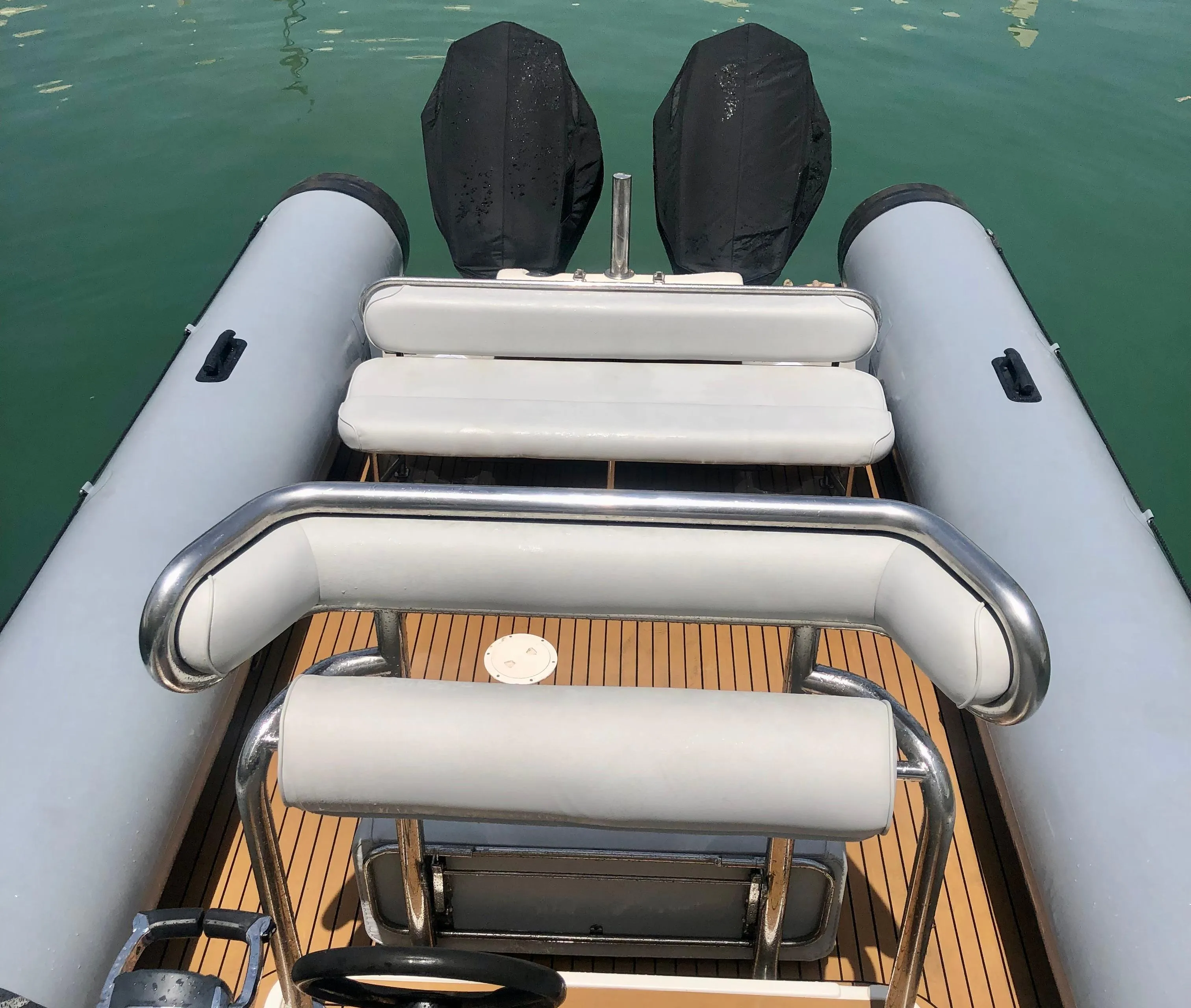 2005 Protector RIB 8.75m boat with dual engines, docked on calm water.