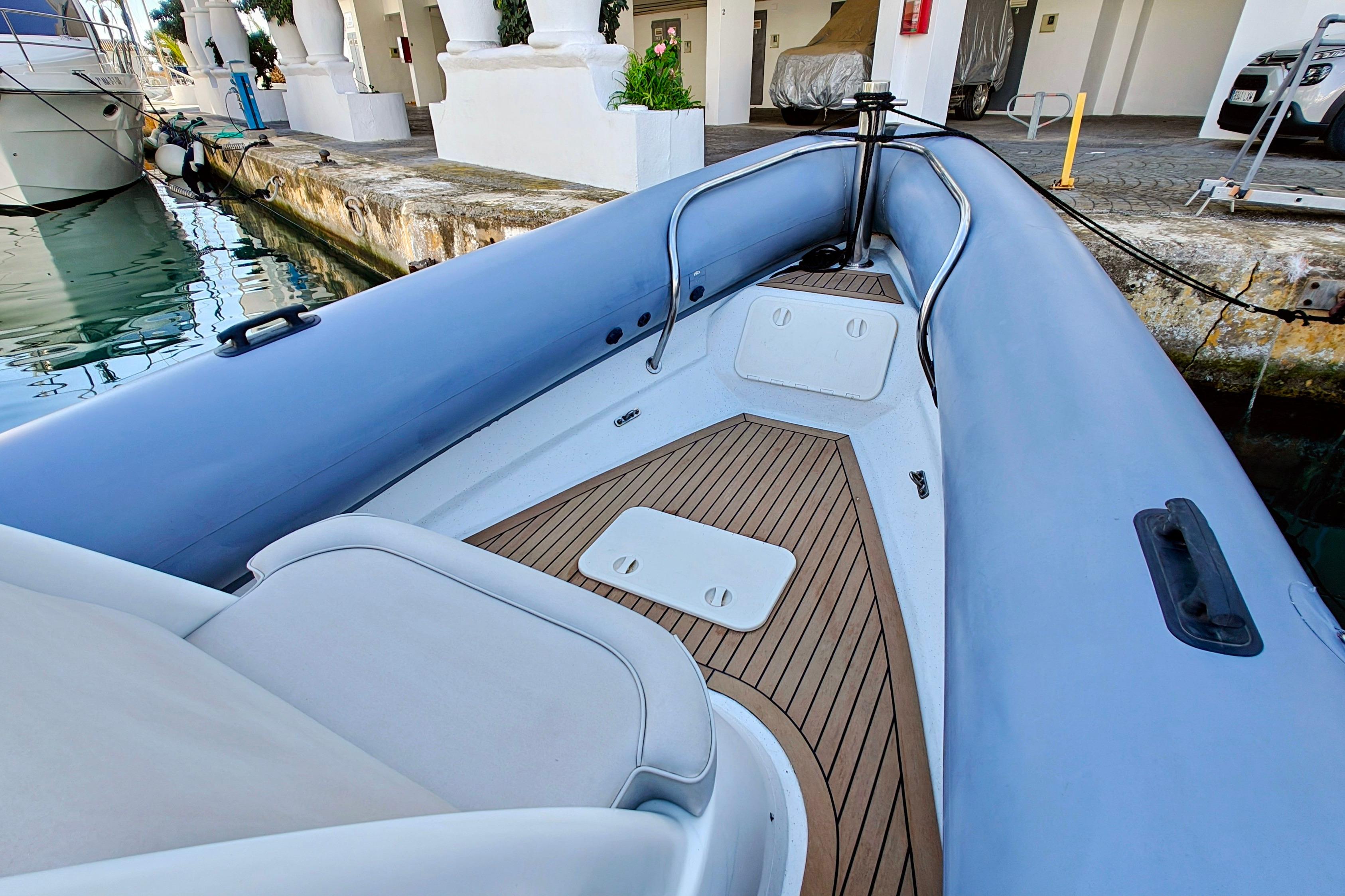 2005 Protector RIB 8.75m boat docked, featuring sleek design and wooden deck.