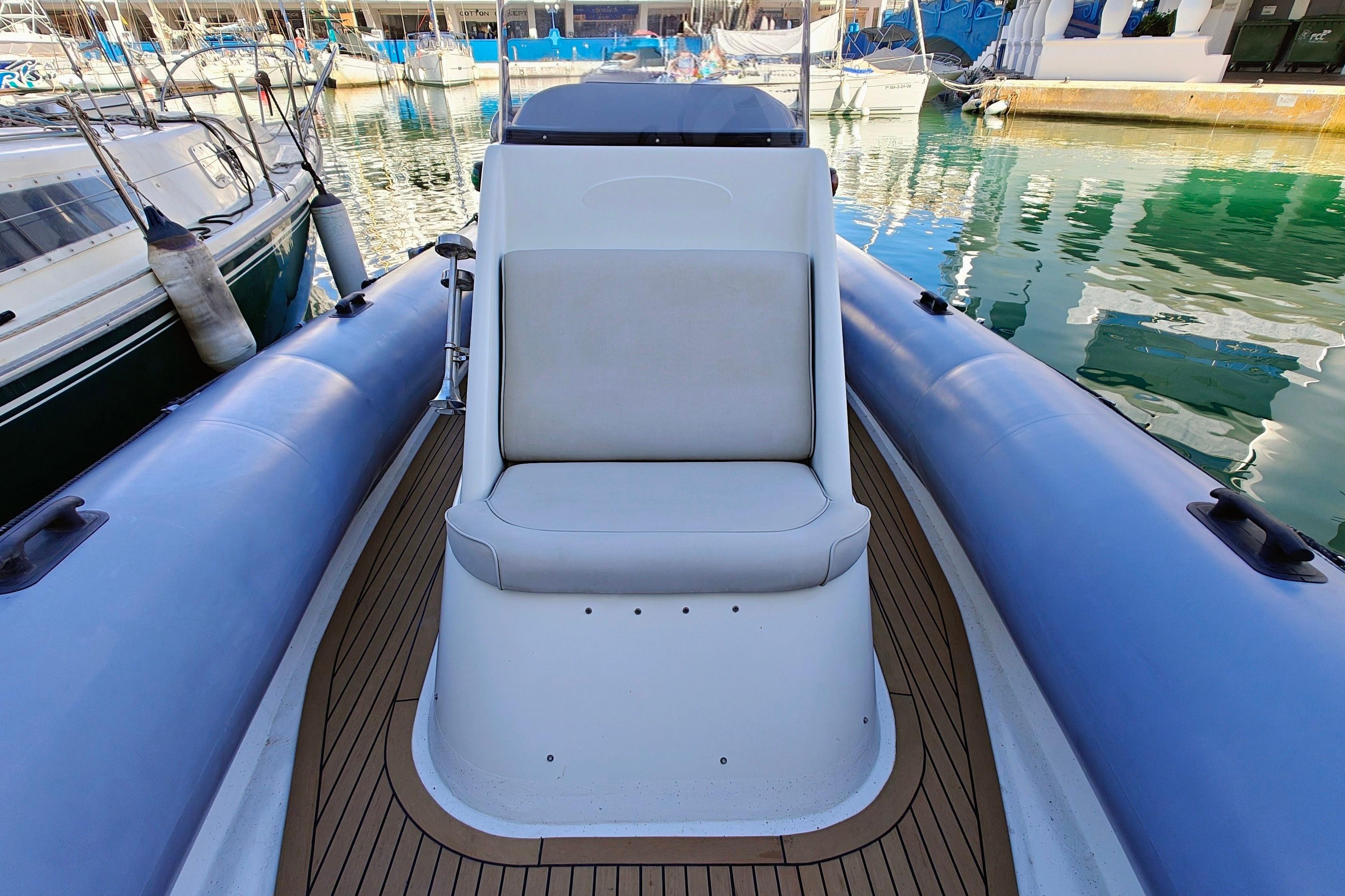 2005 Protector RIB 8.75m boat with cushioned seating, docked in a marina.