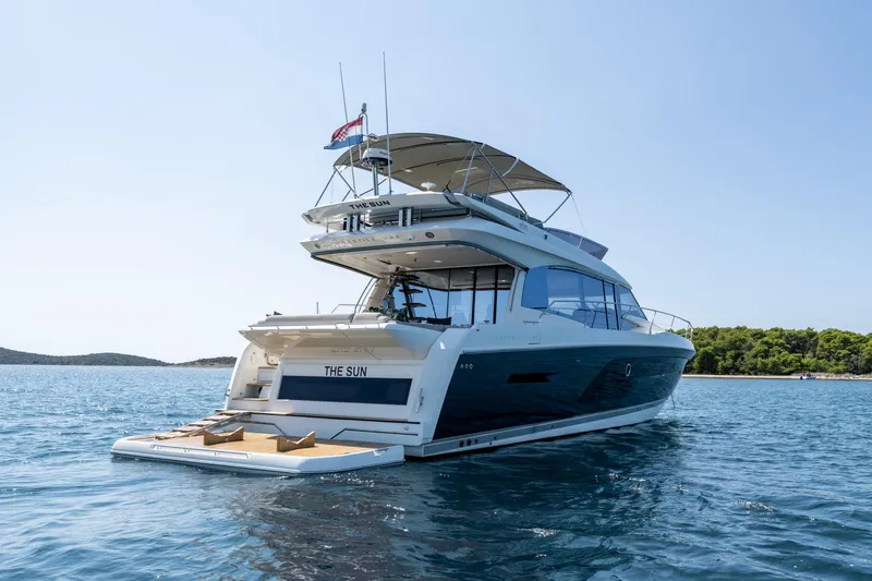 The Sun Yacht Photos Pics Luxury 2020 Prestige 590 yacht on serene blue waters, featuring elegant design and spacious deck.