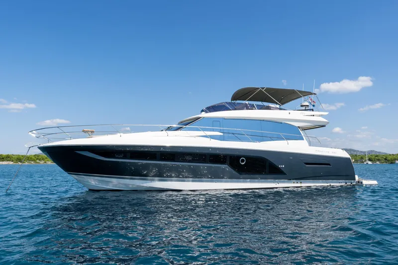 The Sun Yacht Photos Pics Luxury 2020 Prestige 590 yacht on serene blue waters under clear sky.