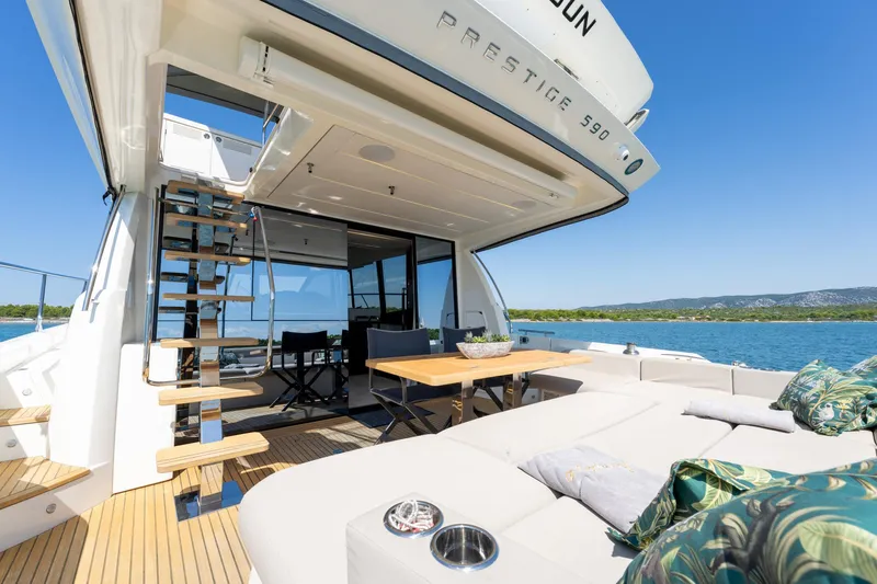 The Sun Yacht Photos Pics Luxurious 2020 Prestige 590 yacht with elegant outdoor seating and scenic ocean view.