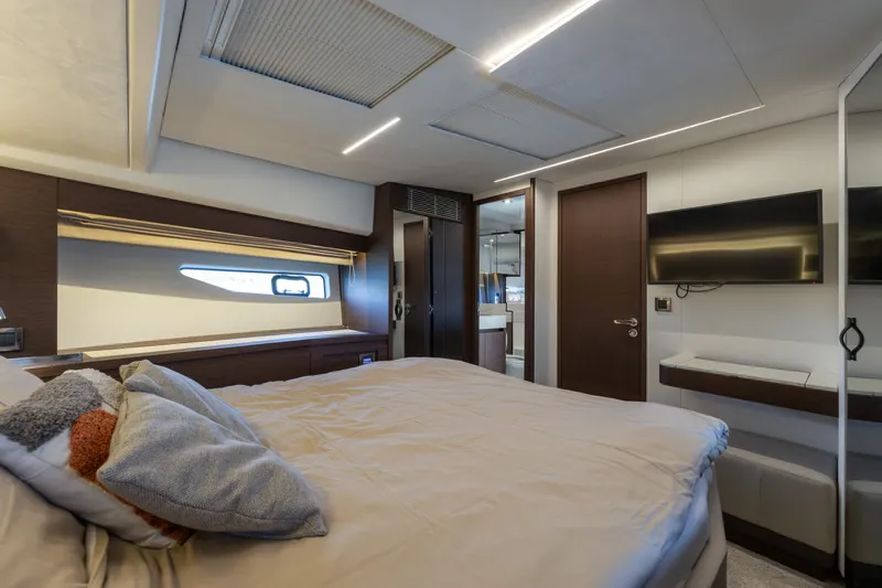 The Sun Yacht Photos Pics Luxurious 2020 Prestige 590 yacht bedroom with modern decor and flat-screen TV.